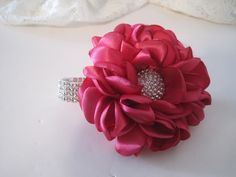 a bridal bouquet on a table with white fabric and crystal brooches in the center