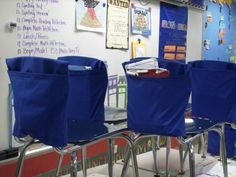 three blue chairs sitting in front of a whiteboard