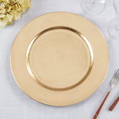 an empty plate on a table with silverware and flowers