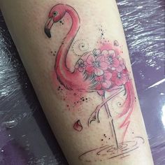 a flamingo with flowers on it's leg is shown in this tattoo design