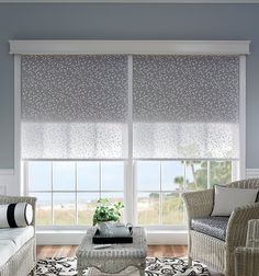 a living room with two chairs and a couch in front of a window that has roman shades on it