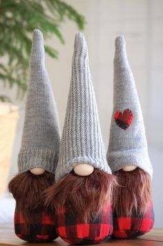 two knitted gnomes with red hearts on their heads are sitting next to each other