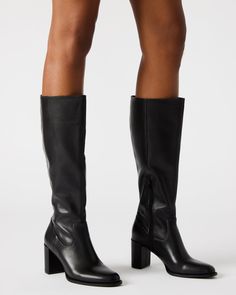 Step up your style with the JOVANA knee-high block heel boot. Crafted with a rounded toe, these boots offer both comfort and sophistication. The perfect addition to any outfit, these boots will elevate your look with their sleek design and sturdy heel. 2.75 inch heel height Size 6 measurements: 14.5 inch shaft circumference, 14.25 inch shaft height Size 8 measurements: 15.5 inch shaft circumference, 15.25 inch shaft height Size 10 measurements: 16.5 inch shaft circumference, 16.25 inch shaft hei Classic Knee-high Boots With Block Heel, Wide Calf Tall Boots For Workwear, Sleek Wide Calf Boots With Stacked Heel, Tall Boots With Reinforced Heel, Classic Knee-high Boots With Stacked Heel For Winter, Wide Calf Knee-high Boots With Padded Heel, Knee-high Heeled Boots With Padded Heel, Wide Calf Knee-high Boots With Reinforced Heel, Wide Calf Knee-high Boots With Padded Heel For Fall