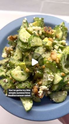 a blue bowl filled with cucumbers and nuts