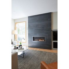 a living room filled with furniture and a fire place next to a large wall mounted fireplace