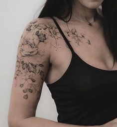 a woman wearing a black tank top with flowers on her arm