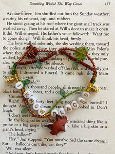 a book page with a bracelet made out of beads and charms on top of it