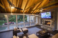 a living room with couches, chairs and a flat screen tv on the wall