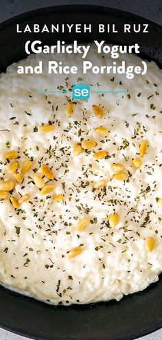 a bowl filled with rice and garnish on top of a black plate next to a spoon