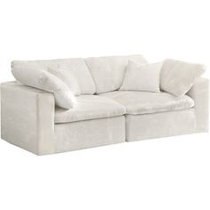 a white couch with two pillows on it's back and one arm facing the camera