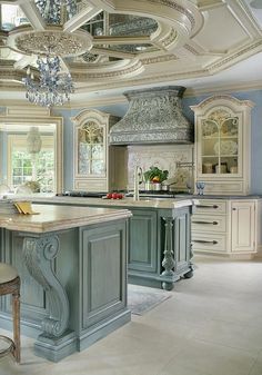 a large kitchen with an island and chandelier hanging from it's ceiling