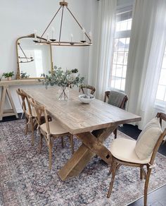 a dining room table with chairs and a rug