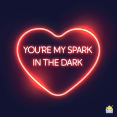 a neon heart with the words you're my spark in the dark