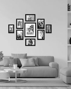 a living room with black and white pictures on the wall, coffee table and bookshelf