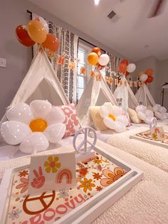 a room filled with lots of white and orange balloons in the shape of teepees