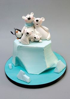 a cake with polar bears and penguins on top is shown for the camera to see