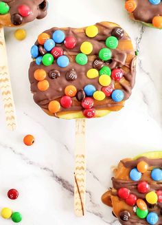 chocolate covered pops with m & m candies on top and candy in the middle