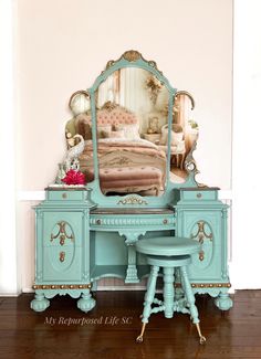 a blue vanity with stool and mirror in a room