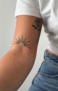 a woman's arm with a rose and sun tattoo on the left side of her arm