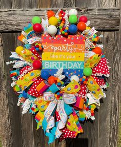 a colorful birthday wreath on a wooden fence