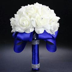 the bridal bouquet has white roses and blue satin ribbons on it's side