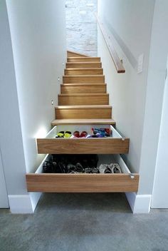 some stairs with shoes in them and the bottom drawer is open to show what's inside