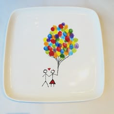 a plate with a drawing of a man and woman holding balloons in the shape of a heart