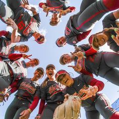 a group of baseball players standing in a huddle with their hands up to the camera