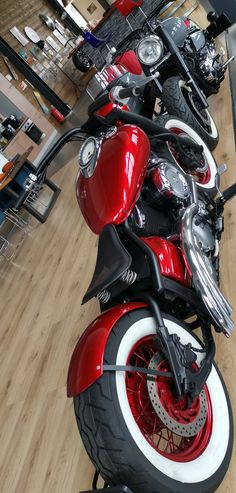 a row of motorcycles parked on top of a wooden floor