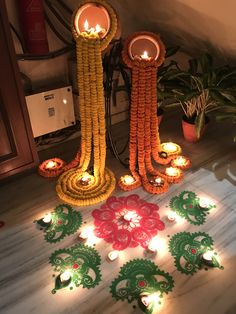 candles are arranged on the floor in front of flowers and decorative decorations with lights around them