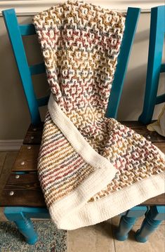 a knitted blanket sitting on top of a blue chair