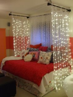 a bed with white lights hanging from it's headboard and pillows on top of it