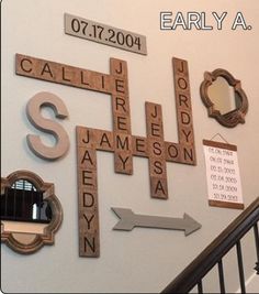 several scrabble tiles are arranged on the wall next to a stair case and mirror