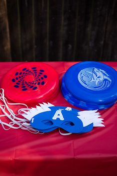 three frisbees sitting on top of a red table