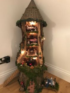 a tree house made out of logs with fairy lights