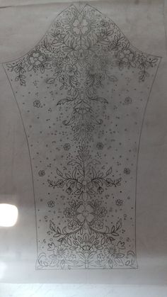 the back side of a piece of cloth with flowers and leaves on it in black ink