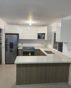 an empty kitchen with white cabinets and stainless steel appliances, is pictured in this image