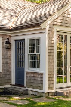 a house with two windows and a blue door