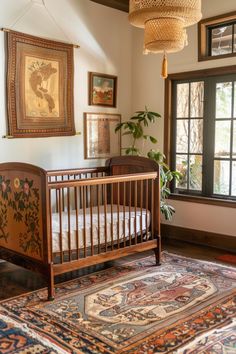 a baby crib in front of a window with pictures on the wall behind it