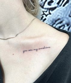 a woman's chest with the words you are my sunshine tattooed on her chest