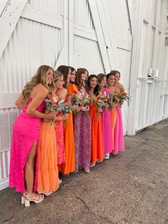 a group of women standing next to each other in front of a white barn door