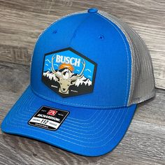 Our Pvc Patch Is A Waterproof, Rugged, And Clean Looking Design. You Can Bet That This Patch Will Look Vibrant For Years To Come. We Only Use The Highest Quality Products And Headwear. We Believe That Our Pvc Patches Beat Out Any Other Type Of Patch Offered On A Hat. Design: Busch Light Mountain Escape Hat: Richardson 112 Color: Blue/ Charcoal Structured, Six-Panel, Mid-Profile 60/40 Cotton/Polyester Adjustable Plastic Snapback Pre-Curved Contrast Stitched Visor Hat Size: 7 - 7 3/4 Nike Outdoor Baseball Cap With Curved Brim, Nike Curved Brim Baseball Cap For Outdoor, Blue Trucker Hat For Outdoor Activities, Nike Curved Bill Baseball Cap For Outdoor, Sporty Blue Baseball Cap For Outdoor Activities, Nike Outdoor Hats, Blue Baseball Cap With Visor For Outdoor Activities, Blue Trucker Baseball Cap With Visor, Blue Trucker Baseball Cap For Outdoor Activities