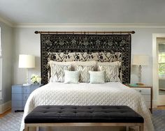 a bedroom with a large bed and rug on the wall