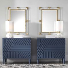 two blue dressers with mirrors and lamps on them