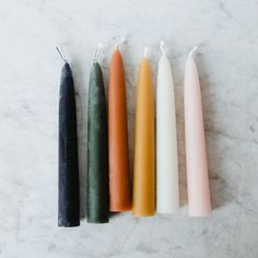 four candles are lined up on a marble surface