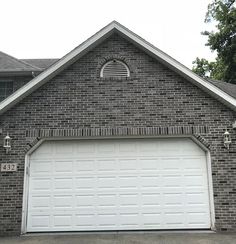 a large brick house with two garage doors