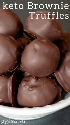 a white bowl filled with chocolate keto brownie truffles on top of a table