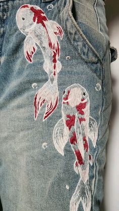 a pair of jeans with fish embroidered on them