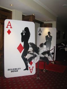 two playing cards are on display in a room with carpeted flooring and red carpet