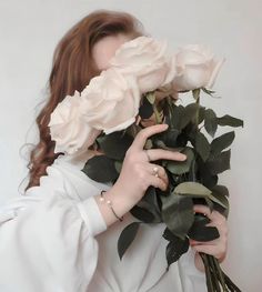 a woman is holding roses in her hands